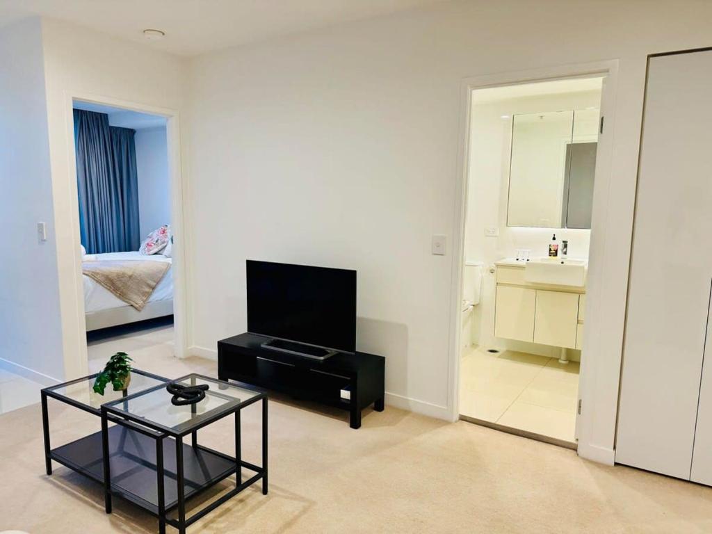 a living room with a television and a table at CASSA TOOWONG - Convenient 1B Apt at Central Location with Parking Managed by The Cassa in Brisbane