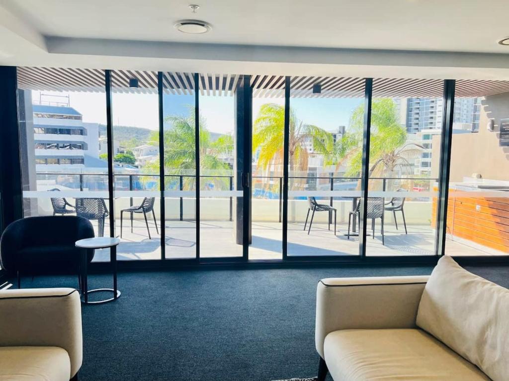 a room with a couch and a table and chairs at CASSA TOOWONG - Convenient 1B Apt at Central Location with Parking Managed by The Cassa in Brisbane
