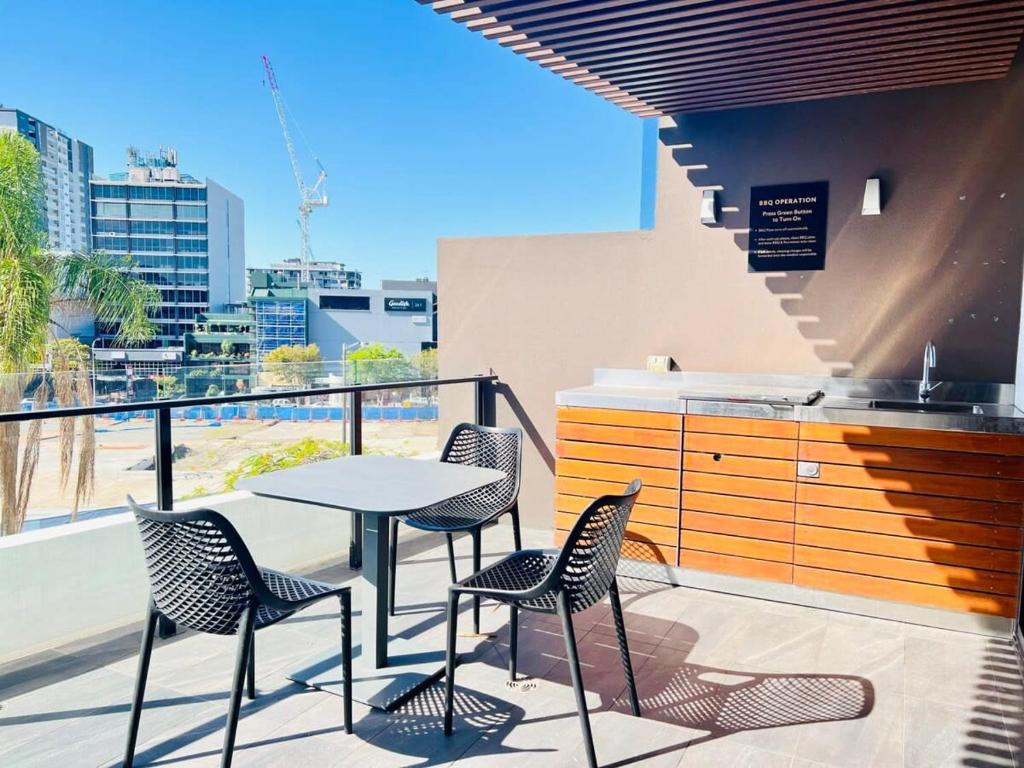 a patio with a table and chairs on a balcony at CASSA TOOWONG - Convenient 1B Apt at Central Location with Parking Managed by The Cassa in Brisbane