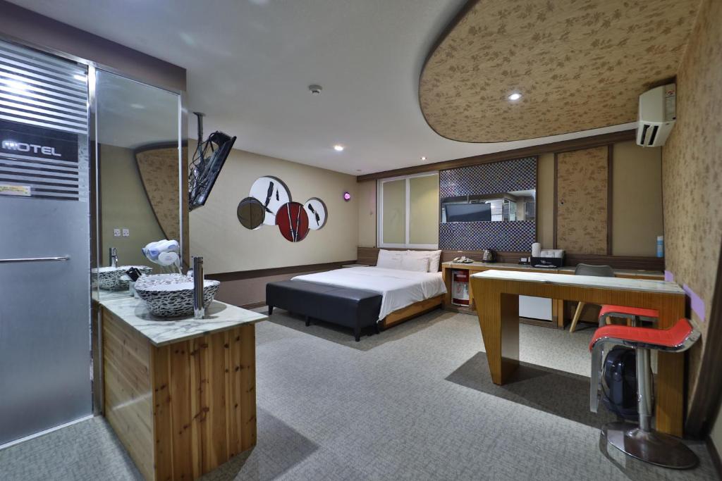 K2 Motel في بوسان: غرفه فندقيه بسرير ومكتب ومطبخ