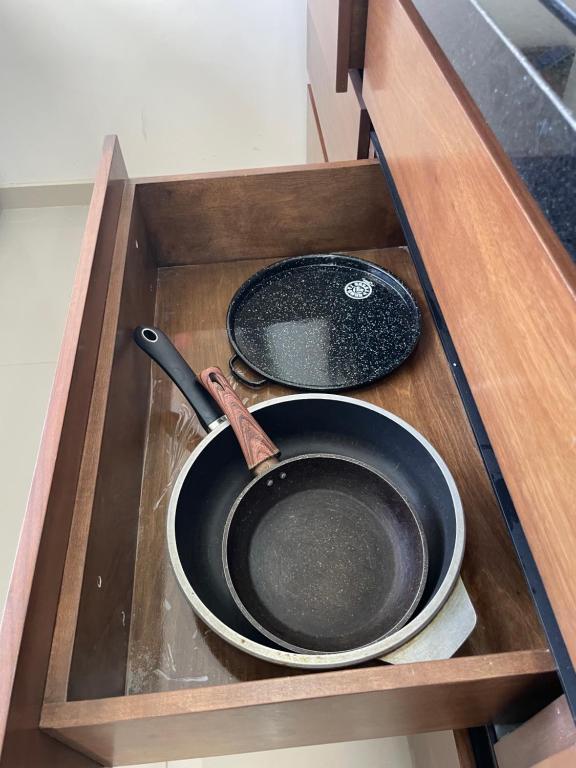 a frying pan and a pan in a wooden drawer at Huichol in Mexicali