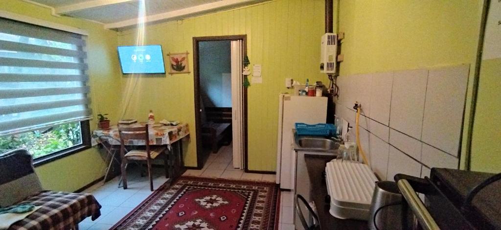 uma pequena cozinha com uma mesa e um frigorífico em Depto interior independiente em Temuco