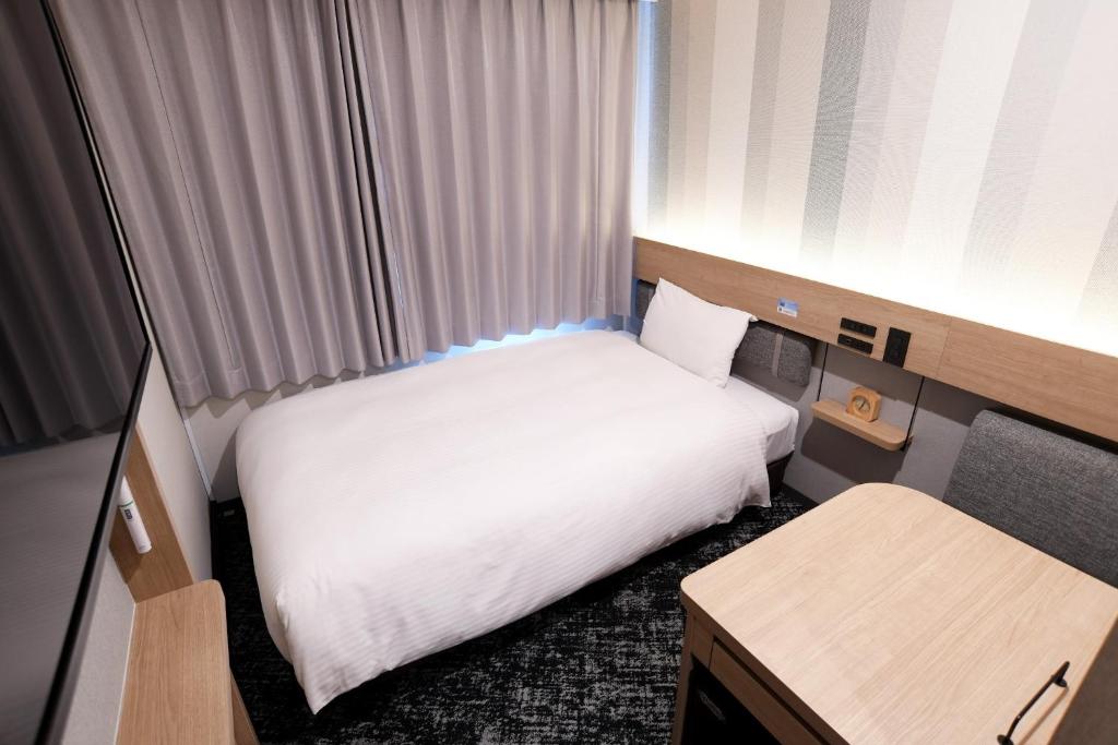 a small hotel room with a bed and a desk at R&B Hotel Otsuka Eki Kitaguchi - Vacation STAY 40485v in Tokyo