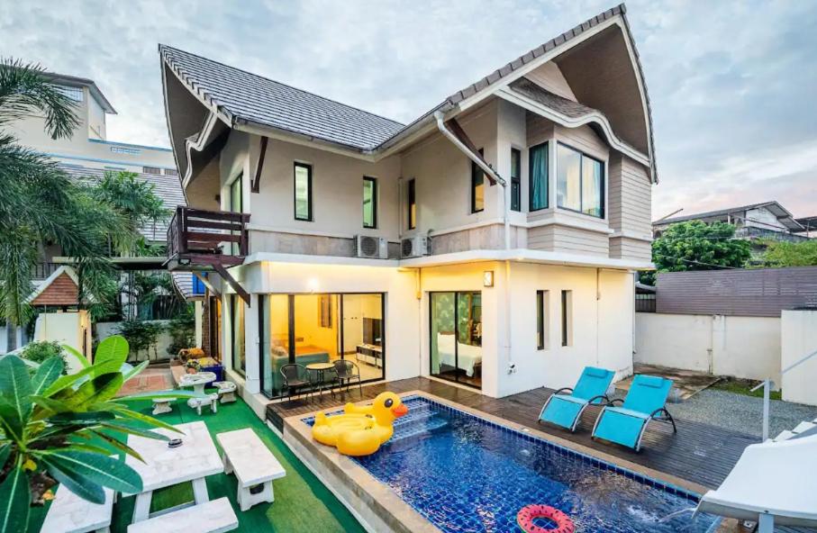 Luxury 250sqm Pool Villa in Central Location 5min to Beach & Walking Street! في باتايا سنترال: بيت فيه مسبح قدام بيت