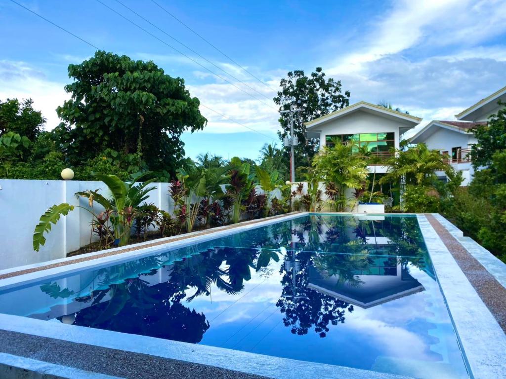 a swimming pool in front of a house at 蓝色引力潜水度假村BLUE GRAVITY.WOW DIVING in Panglao Island