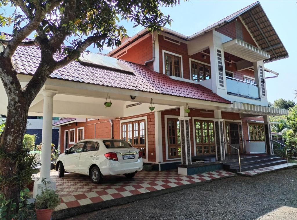 a white car parked in front of a house at Sweet home in Kottayam