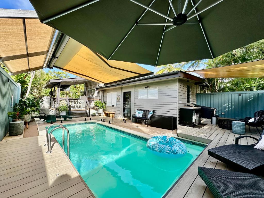 una piscina con ombrellone su una terrazza di Sweet Creek Cottage, Palm Cove, 200m to Beach, Heated Pool, Pets a Palm Cove