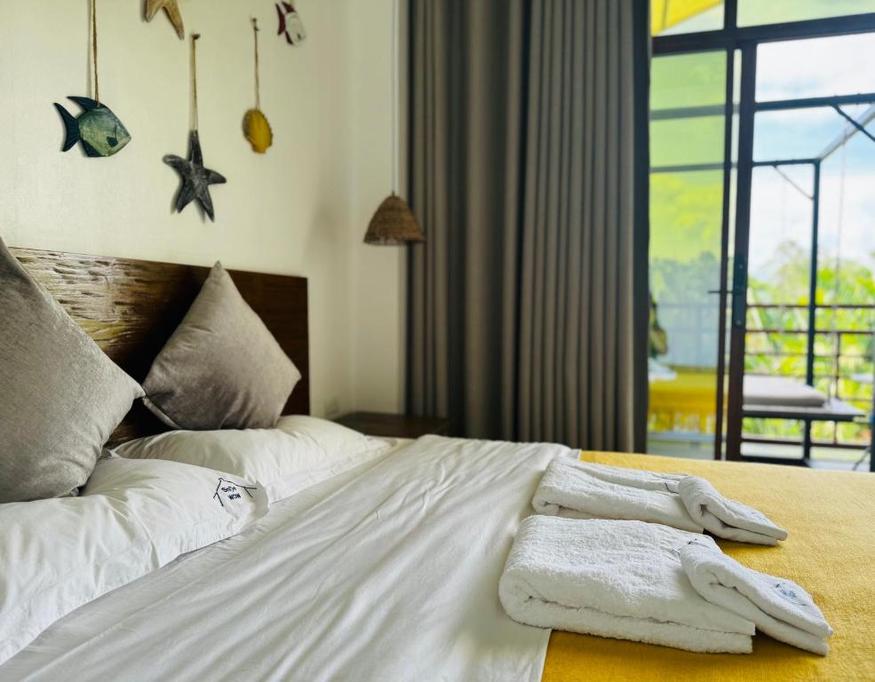 1 dormitorio con 1 cama con toallas en 蓝色引力潜水度假村BLUE GRAVITY.WOW DIVING, en Panglao