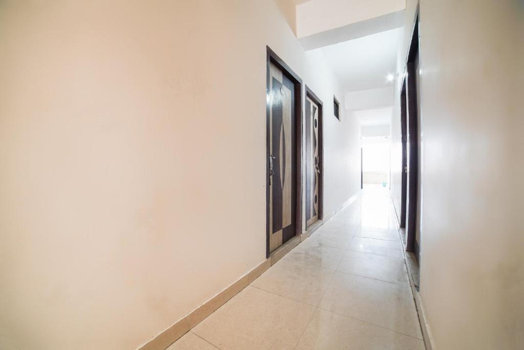 pasillo vacío con puertas y suelo de baldosa en OYO Star Guest House, en Bara Khera