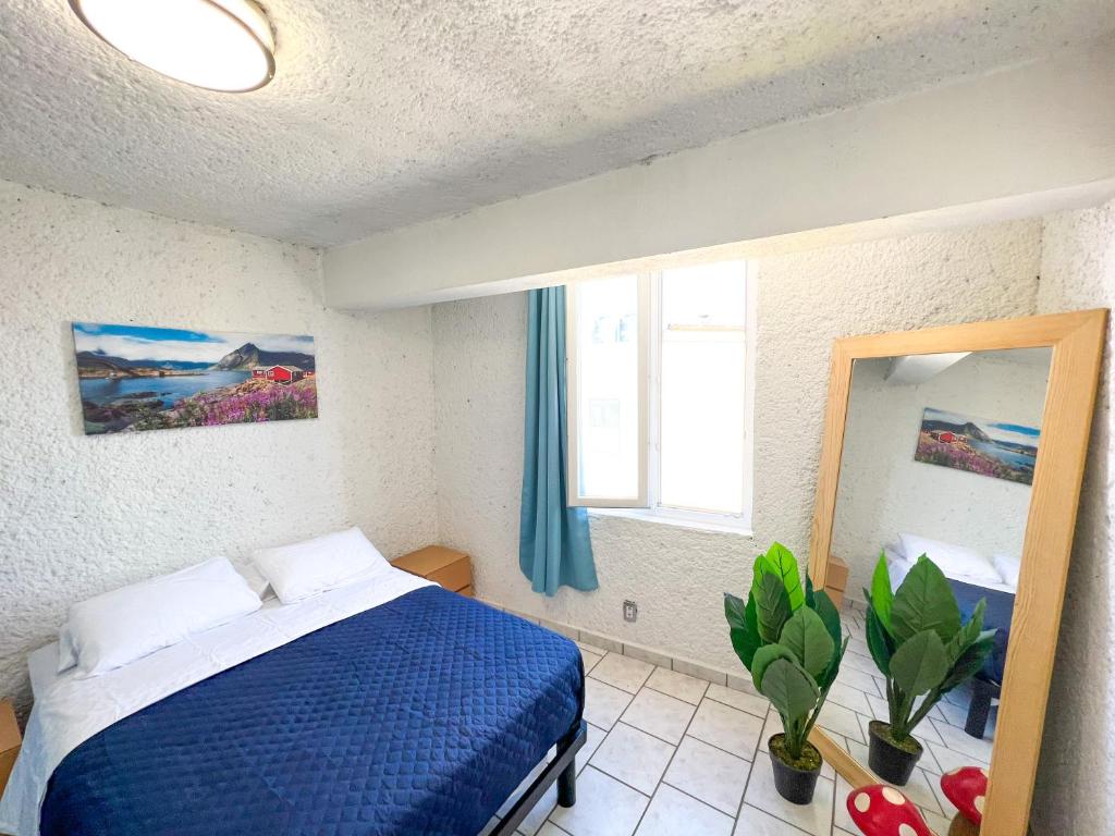 ein Schlafzimmer mit einem blauen Bett und einem Spiegel in der Unterkunft Hotel RJ Querétaro in Querétaro