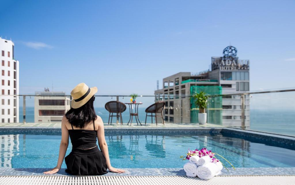 A rooftop pool overlooking the sea and neighboring buildings.