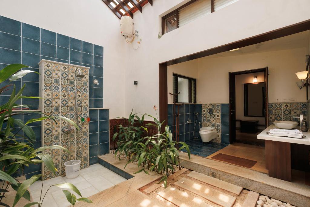 a bathroom with blue tiled walls and a toilet at Sai Vishram Beach Resort in Baindūru