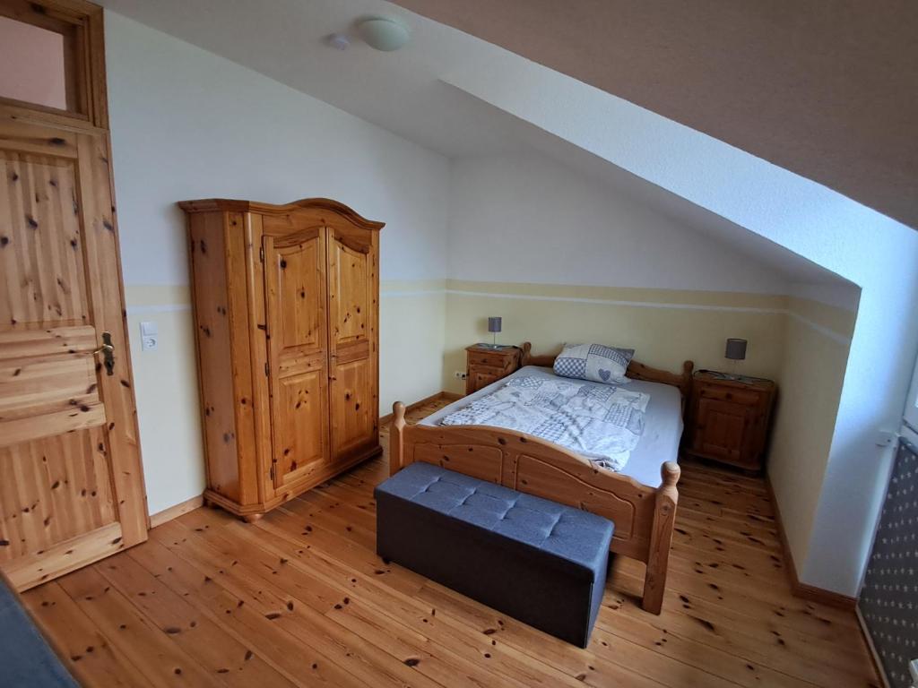 a bedroom with a bed and a wooden floor at 3 Zimmer Obergeschoss in Ahrenviöl