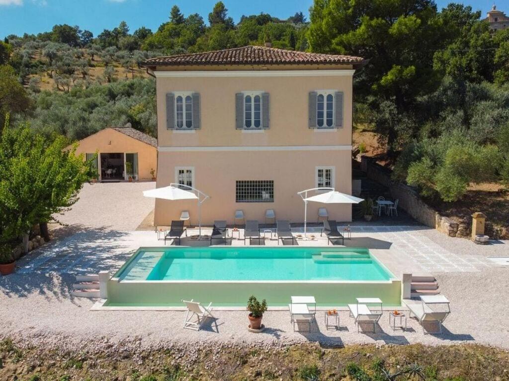 una casa con piscina frente a una casa en Villa Bevagna Comfortable holiday residence, en Bevagna