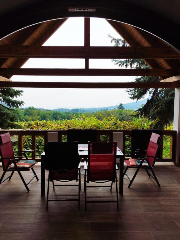 a table and chairs on a balcony with a view at Klára Vendégház in Badacsonyörs