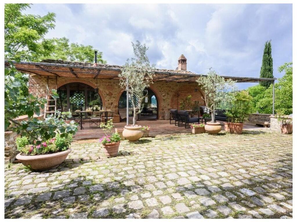 a stone house with a patio with potted plants at Villa Fienile Design in SantʼAppiano