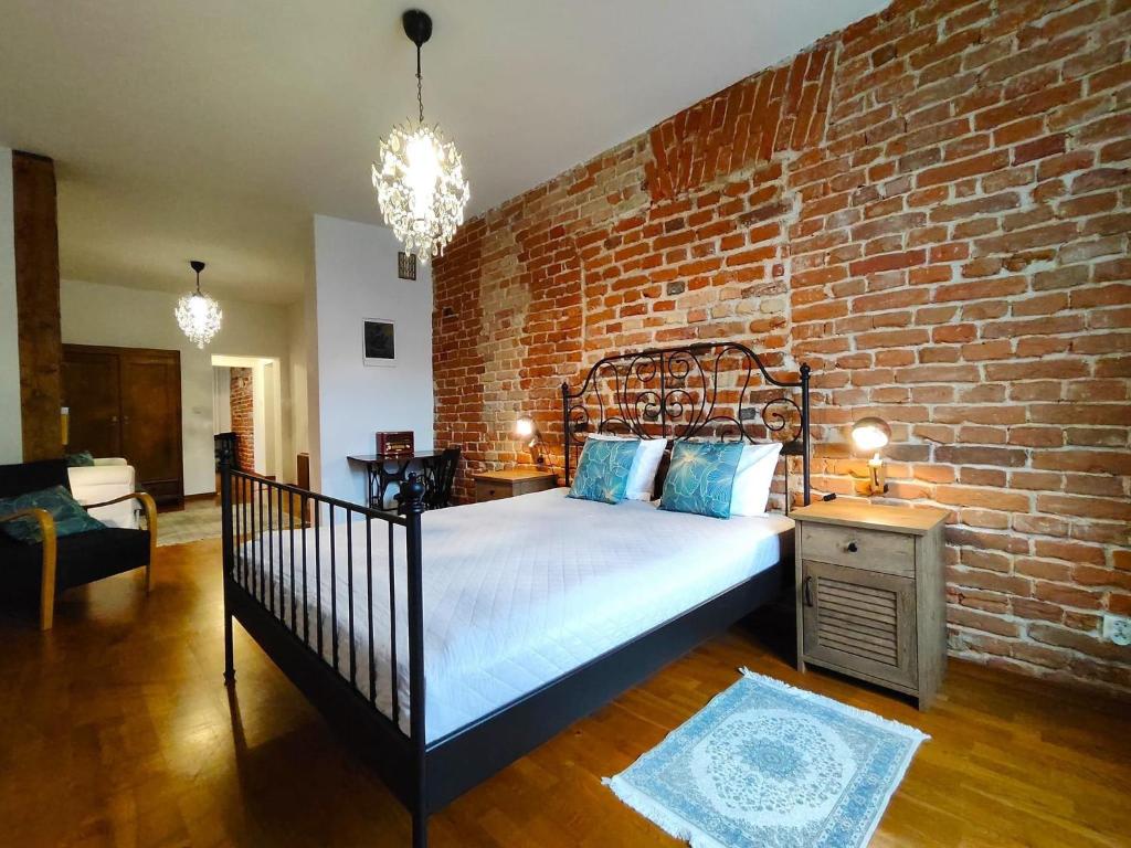 a bedroom with a bed with a brick wall at Apartament Skorpion Centrum in Sanok