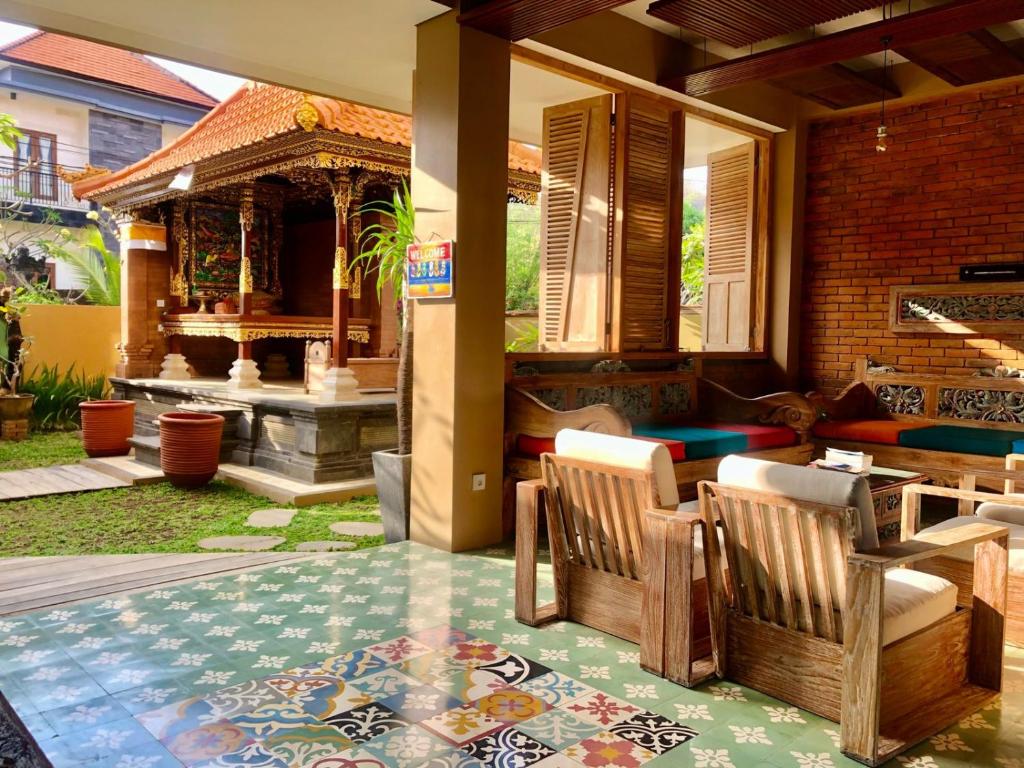 a patio with a table and chairs and a fireplace at Bukawa Lodge Jimbaran in Jimbaran