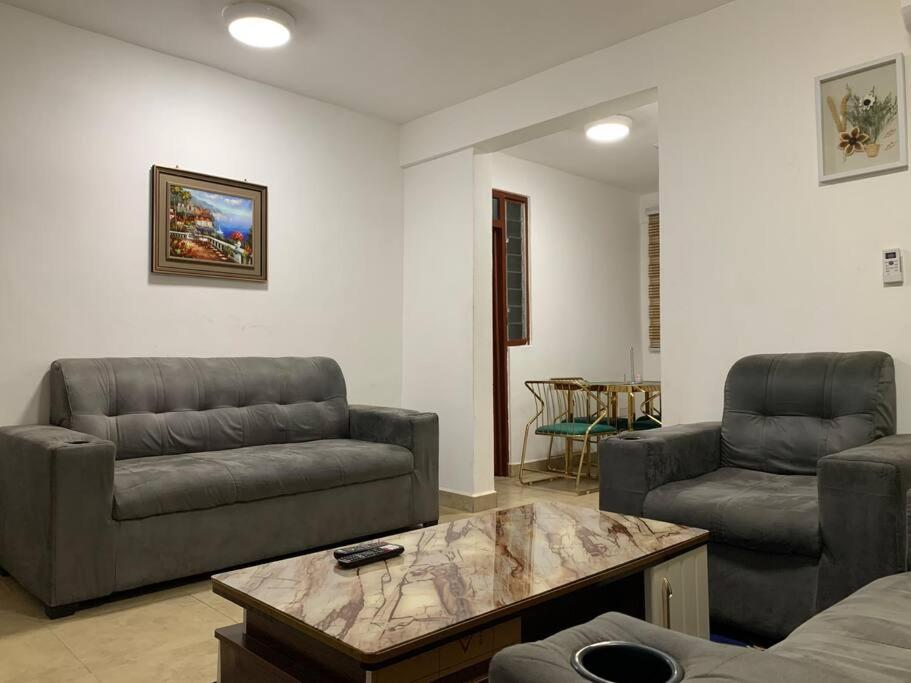 ein Wohnzimmer mit 2 Sofas und einem Couchtisch in der Unterkunft Modern Cozy 1Bedroom Space near KNUST & Kumasi Airport in Kumasi