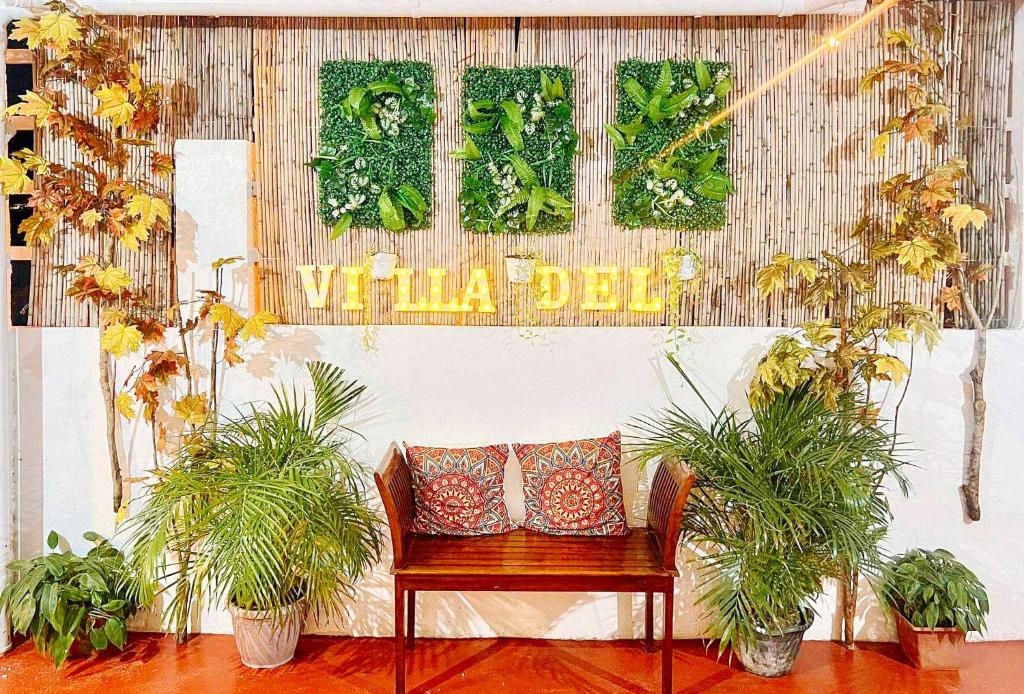 a bench with two pillows in a room with plants at The Lavana Villa Del Matabungkay by RedDoorz in Lian