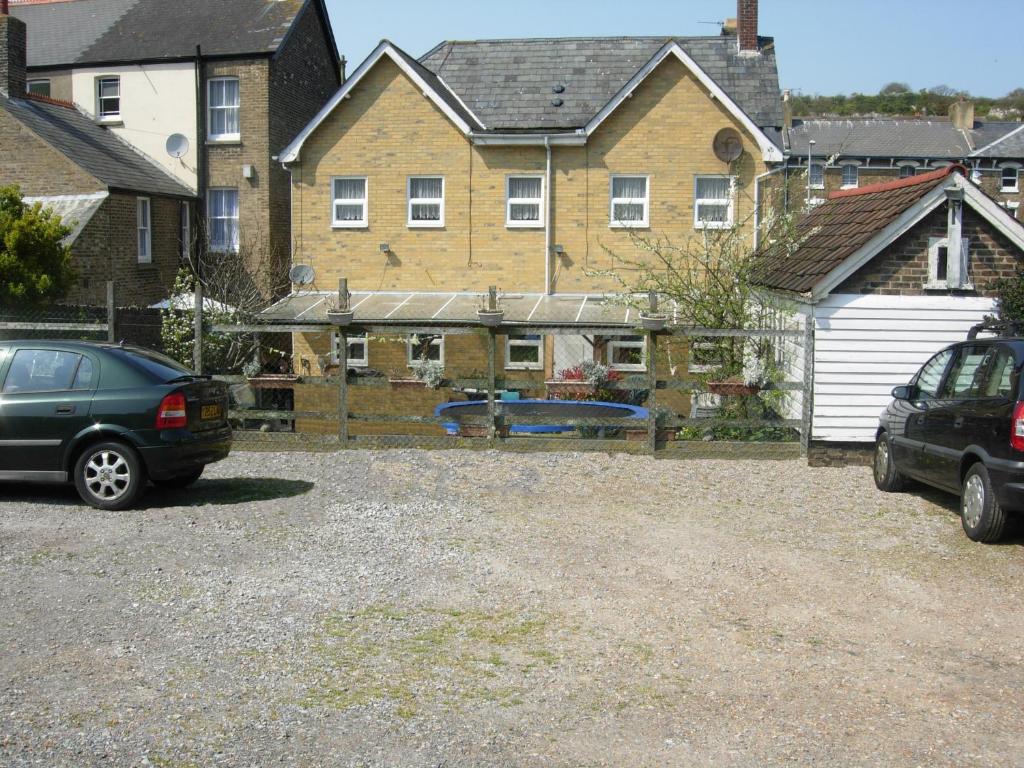 two cars parked in a parking lot in front of a house at Longfield Guest House in Dover