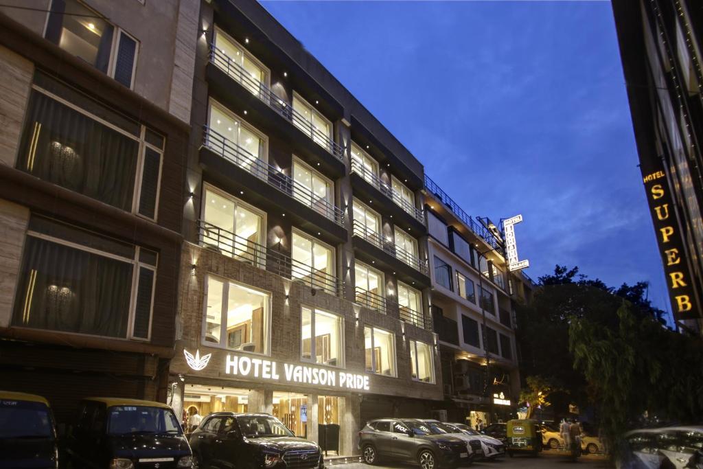 um edifício de hotel com carros estacionados em frente em The Vanson Pride Delhi em Nova Deli