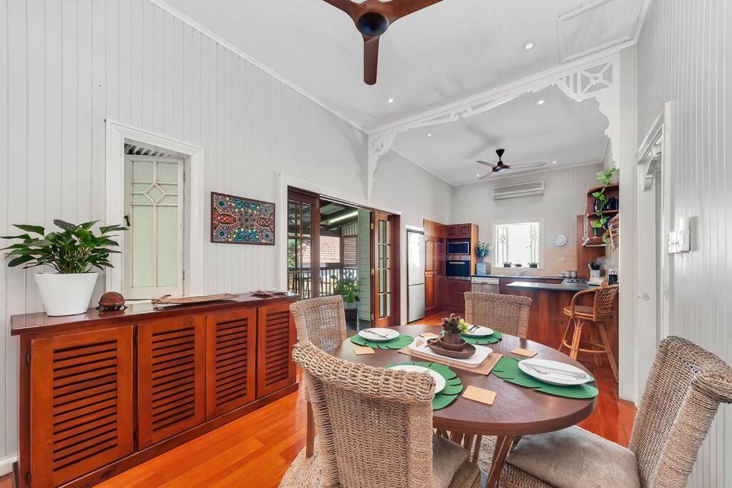 a kitchen and dining room with a table and chairs at Masterfully Restored Queenslander Near Esplanade in Cairns North