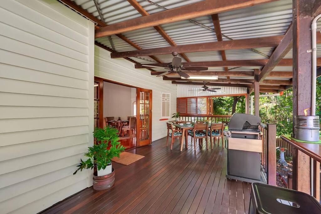 an outdoor kitchen and dining area of a house at Masterfully Restored Queenslander Near Esplanade in Cairns North