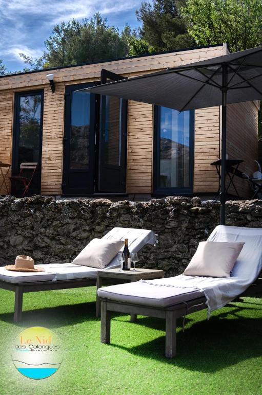 deux lits assis sur l'herbe devant une maison dans l'établissement Le Nid des Calanques et son Jacuzzi, à Marseille