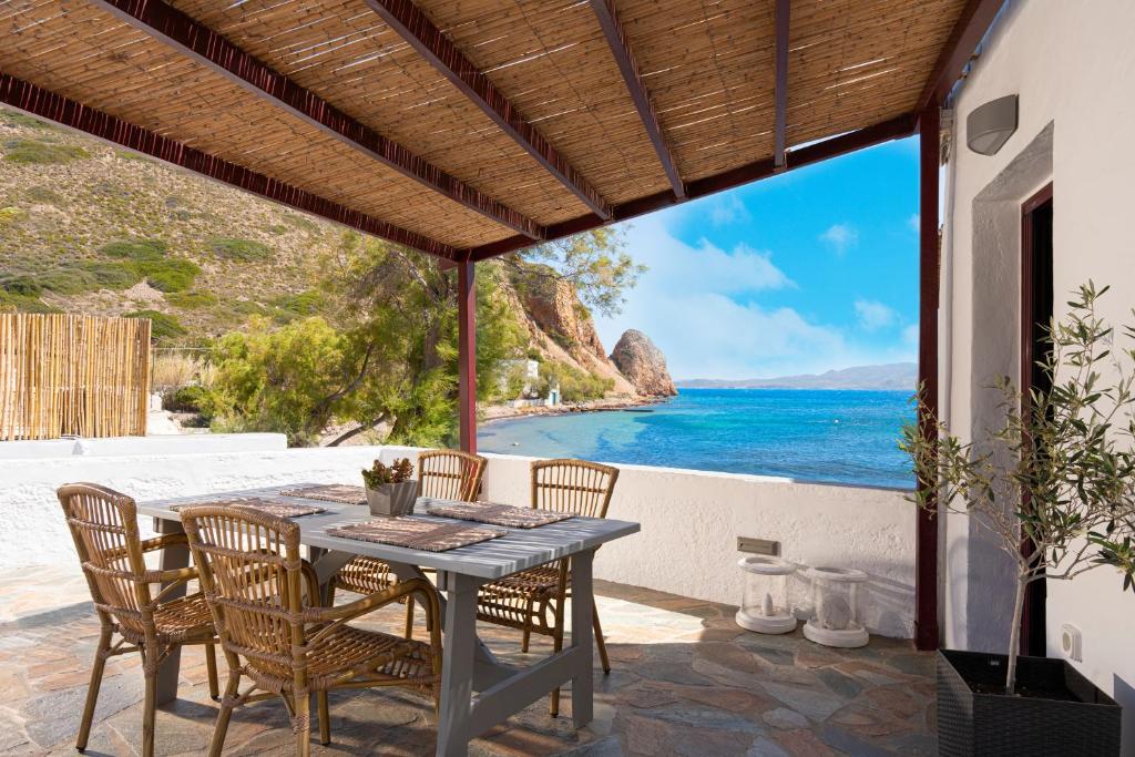 a table on a patio with a view of the ocean at Skinopi Fisherman's house in Péran Triovasálos
