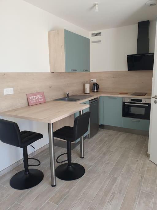 une cuisine avec une table en bois et deux chaises dans l'établissement Studio cosy maison neuve Rodger, à Médis