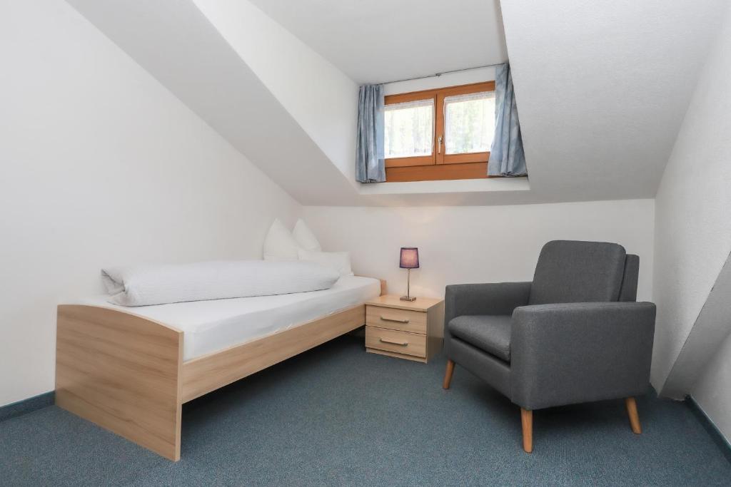 1 dormitorio pequeño con 1 cama y 1 silla en Hotel Langeshof, en Anterivo