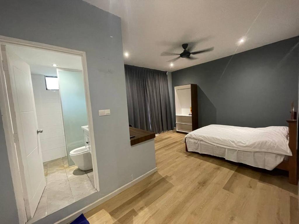 ein Schlafzimmer mit einem Bett und ein Badezimmer mit einem WC in der Unterkunft Homestay KNK in Tawau