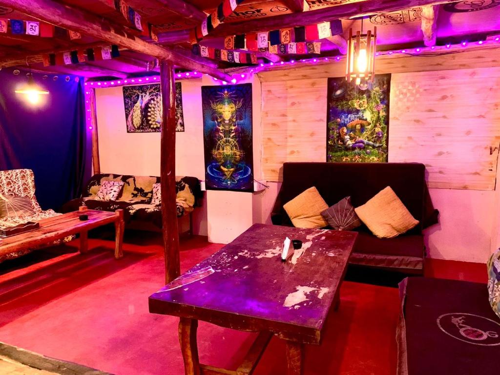 a living room with a table and purple lights at WTF! What The Forest vashisht manali in Manāli