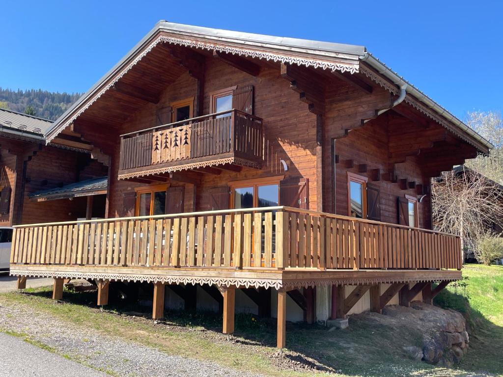 a large wooden house with a large deck at Chalet Pura Vida Morillon Samoëns Grand Massif 6-8 in Morillon