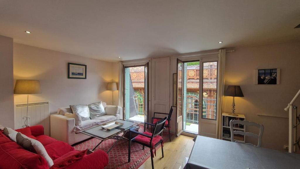 salon z czerwoną kanapą i stołem w obiekcie Grand Appartement La Source d'Evian w mieście Évian-les-Bains