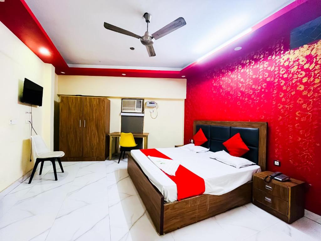 1 dormitorio con cama y pared roja en Hotel Bashistha - 2Mint Walk Nizamuddin Railwy en Nueva Delhi