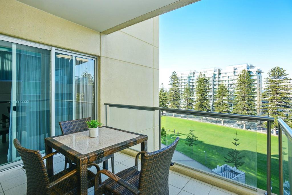 a patio with a table and chairs on a balcony at Pier Apartment - Glenelg Views - No 506 in Adelaide