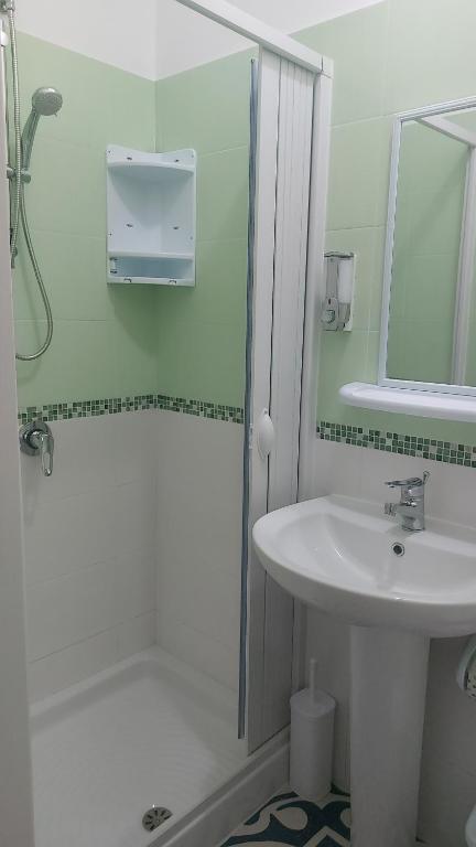 a white bathroom with a sink and a shower at Benvenuti al Sud B&B in Macari