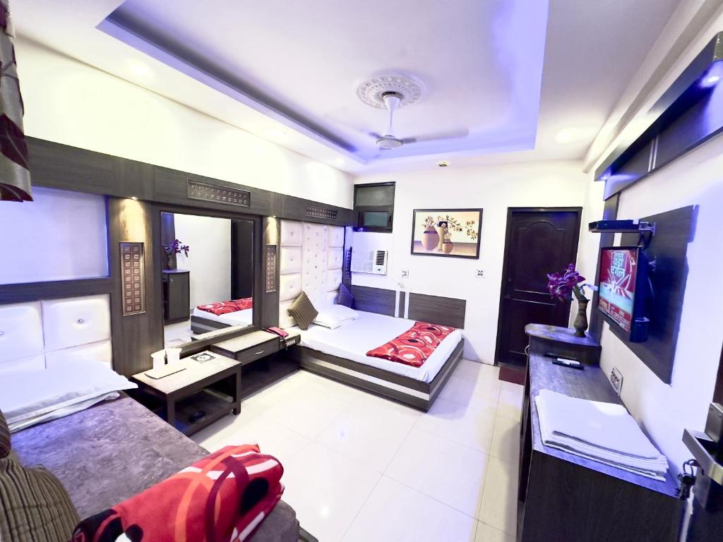 duży pokój z 2 łóżkami i kanapą w obiekcie PEACE POINT FAMILY HOTEL By AKJ w Nowym Delhi