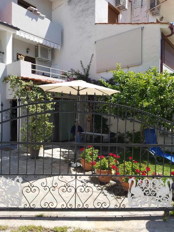 patio z parasolem i kwiatami na płocie w obiekcie Ermionis home w mieście Palaión Tsiflíkion