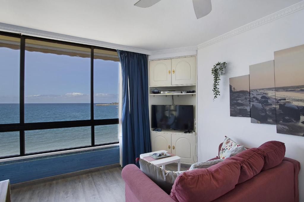 a living room with a couch and a view of the ocean at Patalavaca Beach House in Patalavaca