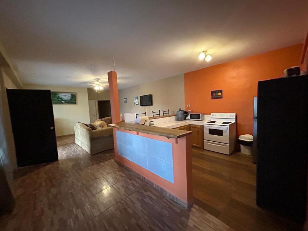 uma grande cozinha e sala de estar com paredes laranja em Villas La Romana #2 em La Ceiba