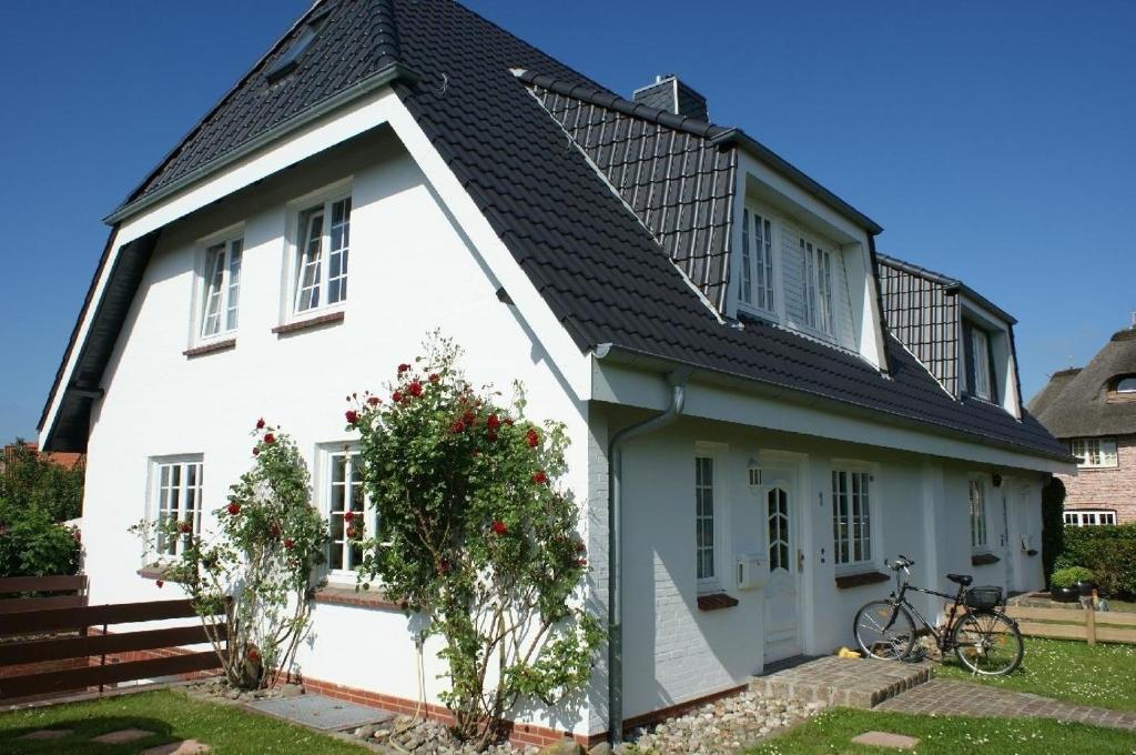 una casa blanca con techo negro en Haus Jölhuk, en Morsum