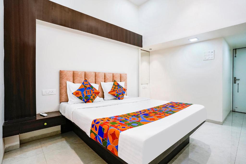 a bedroom with a large bed with a colorful blanket at FabHotel Saroj Inn in Nashik