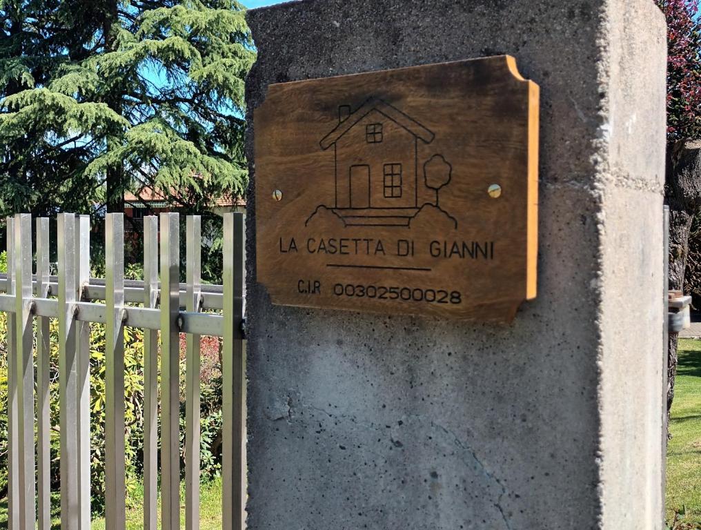 una señal en una pared junto a una valla en La casetta di Gianni, en Borgo Ticino