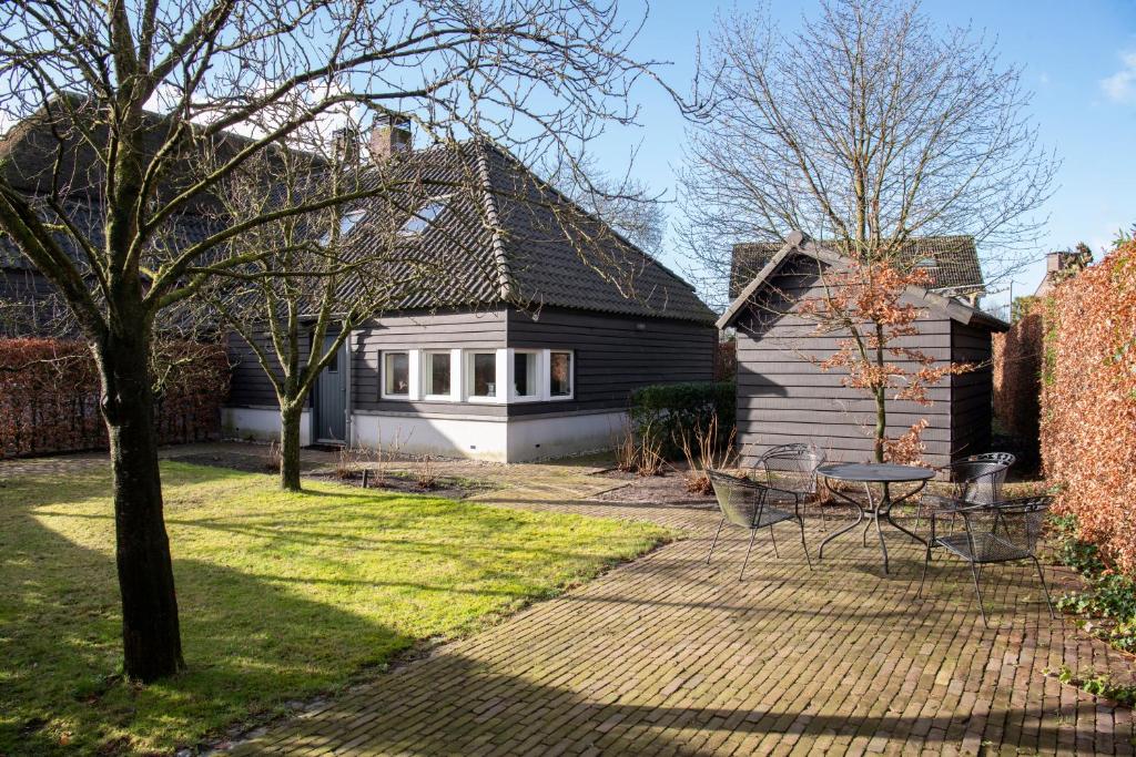 ein Haus mit einem Tisch und Stühlen im Hof in der Unterkunft B&B aan het Dijksteegje in Sint-Oedenrode