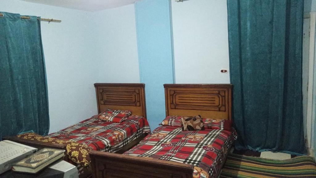 duas camas num quarto com um gato sentado entre elas em مصايف الاسكندرية الزهراء em Alexandria
