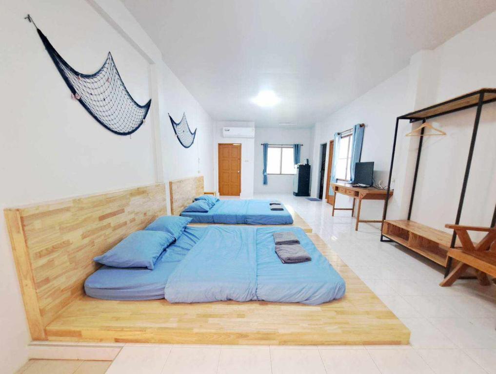 Zimmer mit 3 Betten und blauen Kissen in der Unterkunft พีพี วิลล่า บางแสน รีสอร์ท in Ban Bang Saen (1)