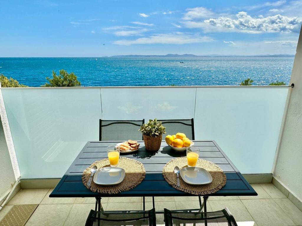 a table on a balcony with a view of the ocean at meda chica in Roses